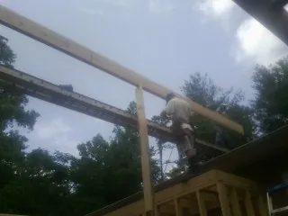 Carpenter setting a ridge beam over a new addition frame — Ice Dam Removal by Roofing Brothers in Rockaway