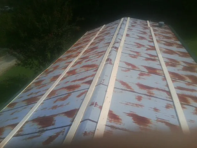 Rusted metal roof panels with new wood purlins before replacement — Storm Damage Roof Repair in Rockaway by Roofing Brothers