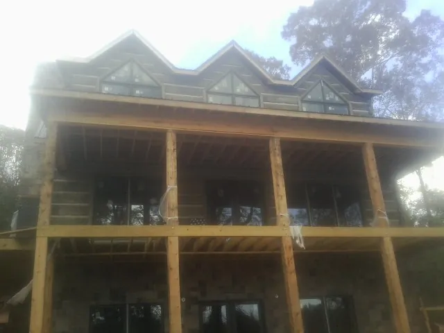 Dormers and porch framing on a large log home under construction — Roof Coating work by our crew in Rockaway