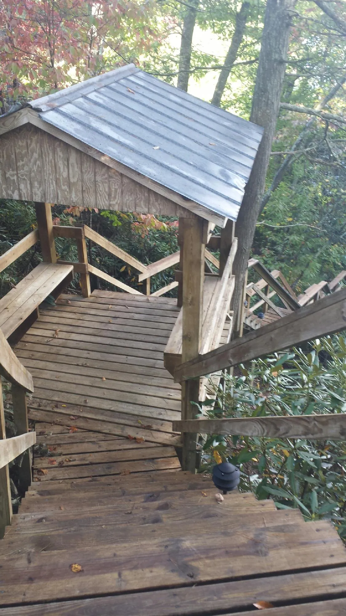 Metal roofed shelter over wooden steps on a wooded walkway — Skylight Repair & Installation work by our crew in Rockaway